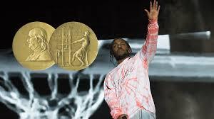 In the foreground is the Nobel Prize for music. In the background is Kendrick Lamar wearing a white shirt with red/pink tie-dye pattern