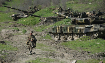 A solider walking away from several tanks